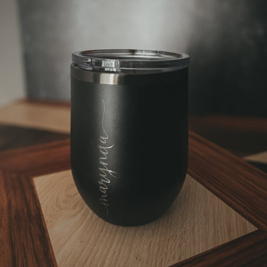 Black insulated tumbler with 'Marynda' engraving on a wooden surface