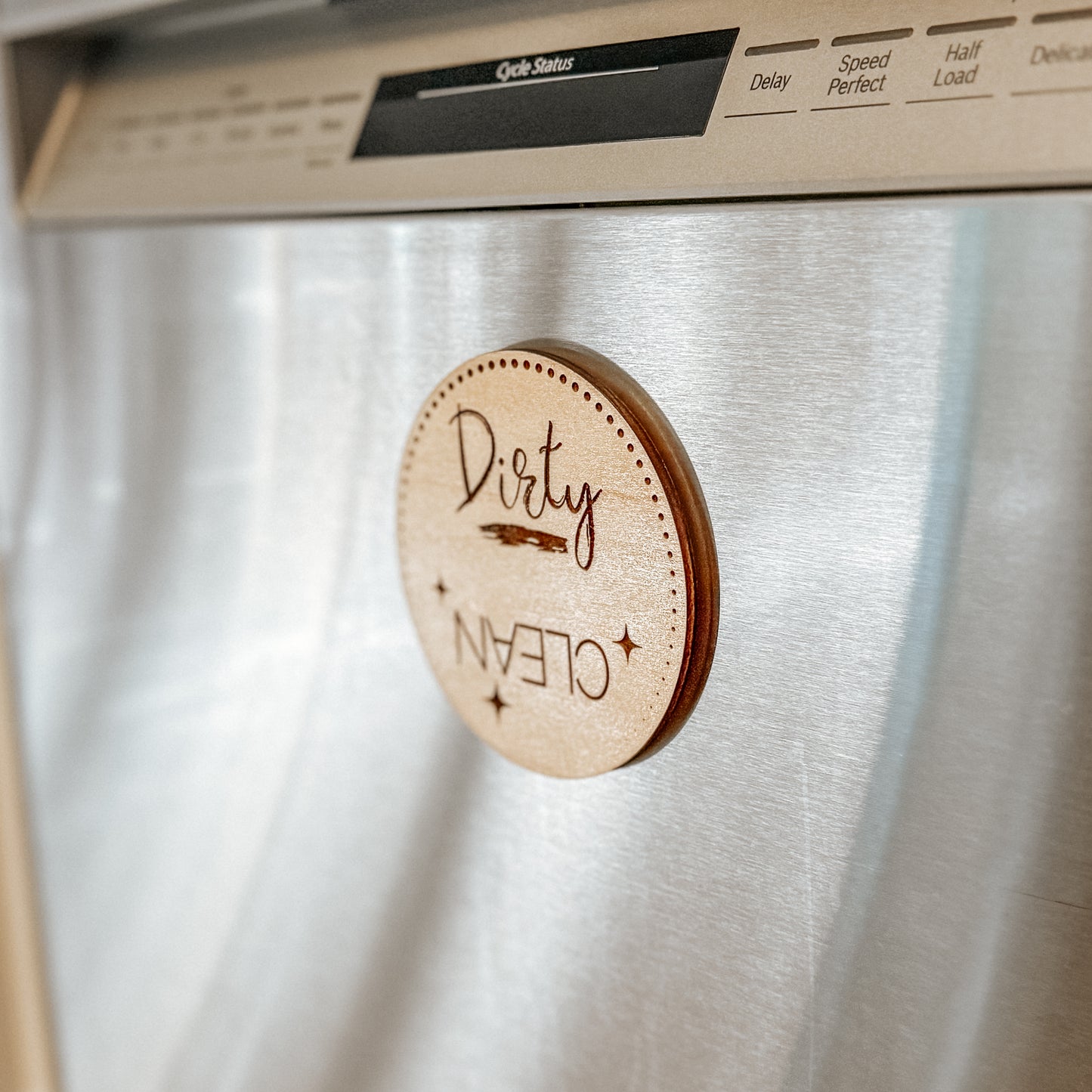 Wooden 'Dirty' or 'Clean' dishwasher magnet on a stainless steel dishwasher.