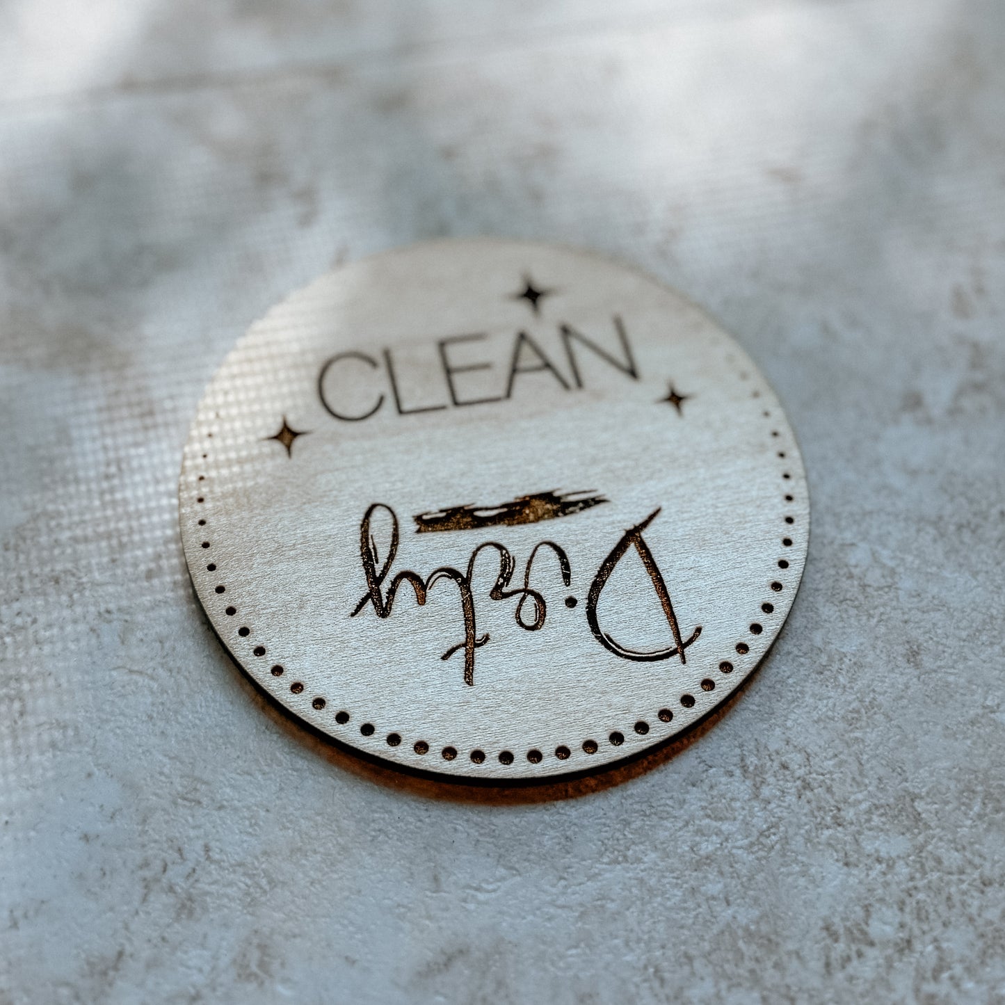 Round 'CLEAN' label with signature on a textured surface