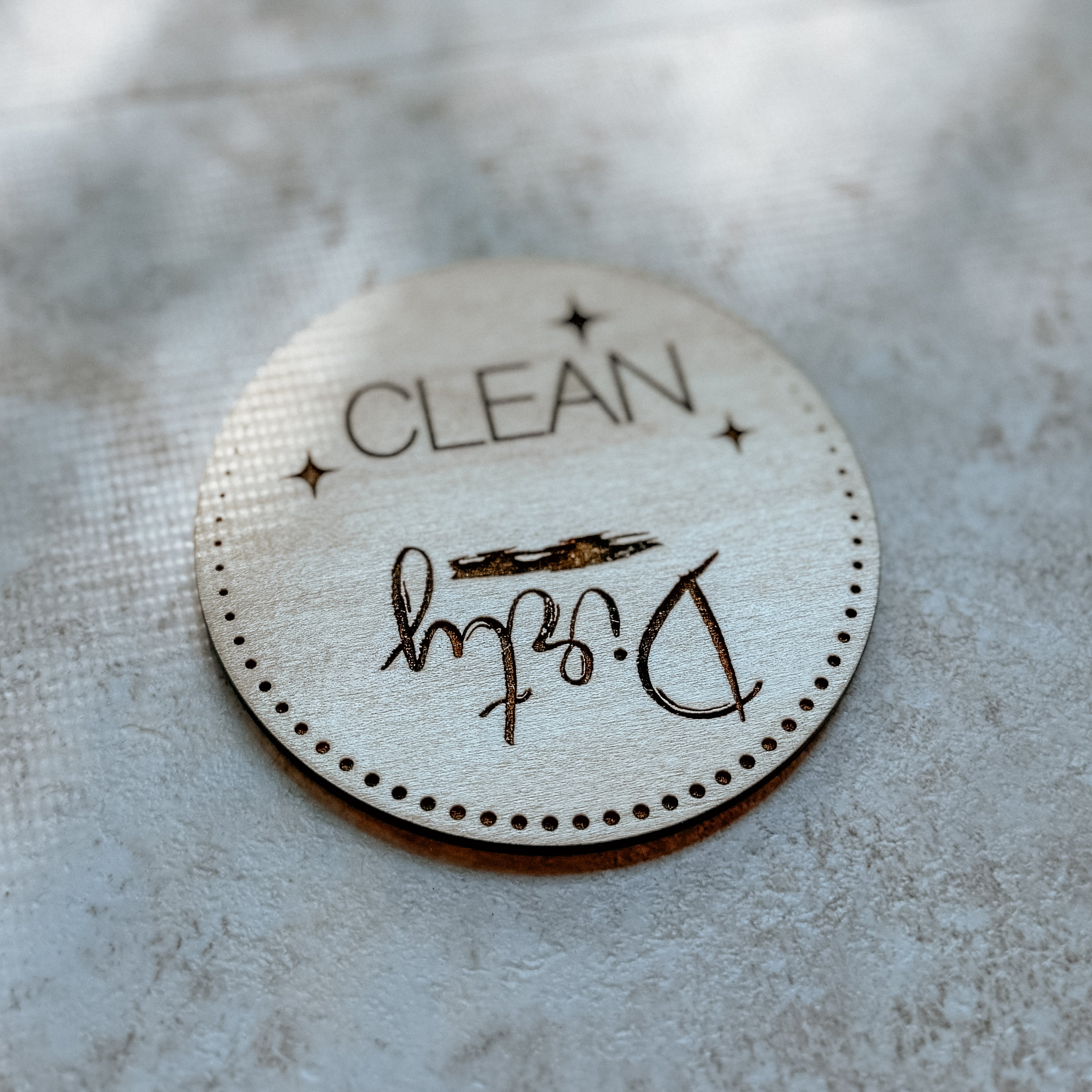 Round 'CLEAN' label with signature on a textured surface