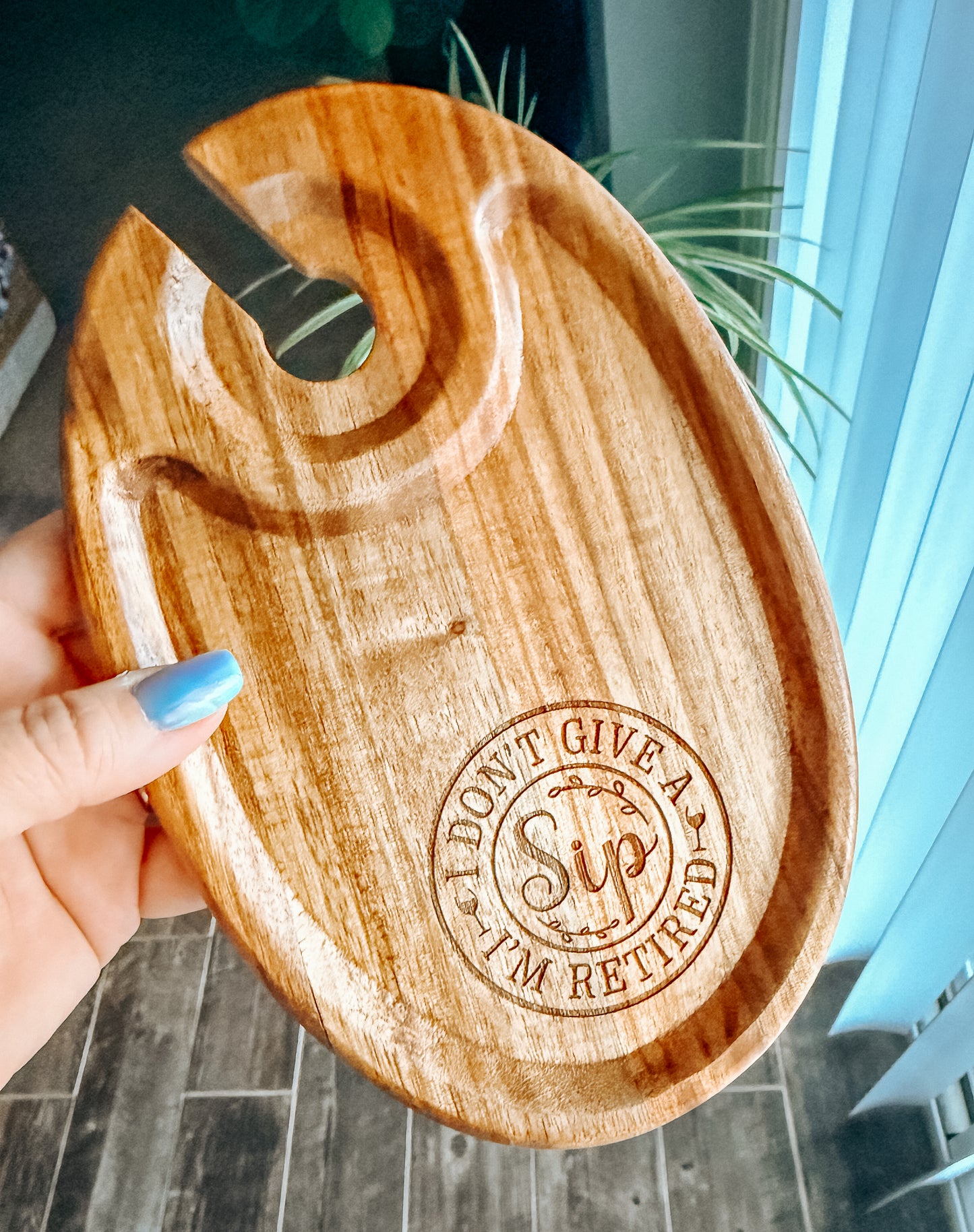Wooden tray with 'I Don't Give a Sip, I'm Retired' engraving held by a hand.