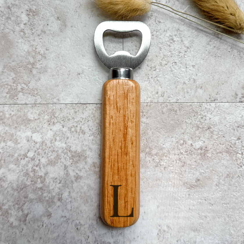 Bottle opener with wooden handle and metal cap catcher on a gray surface