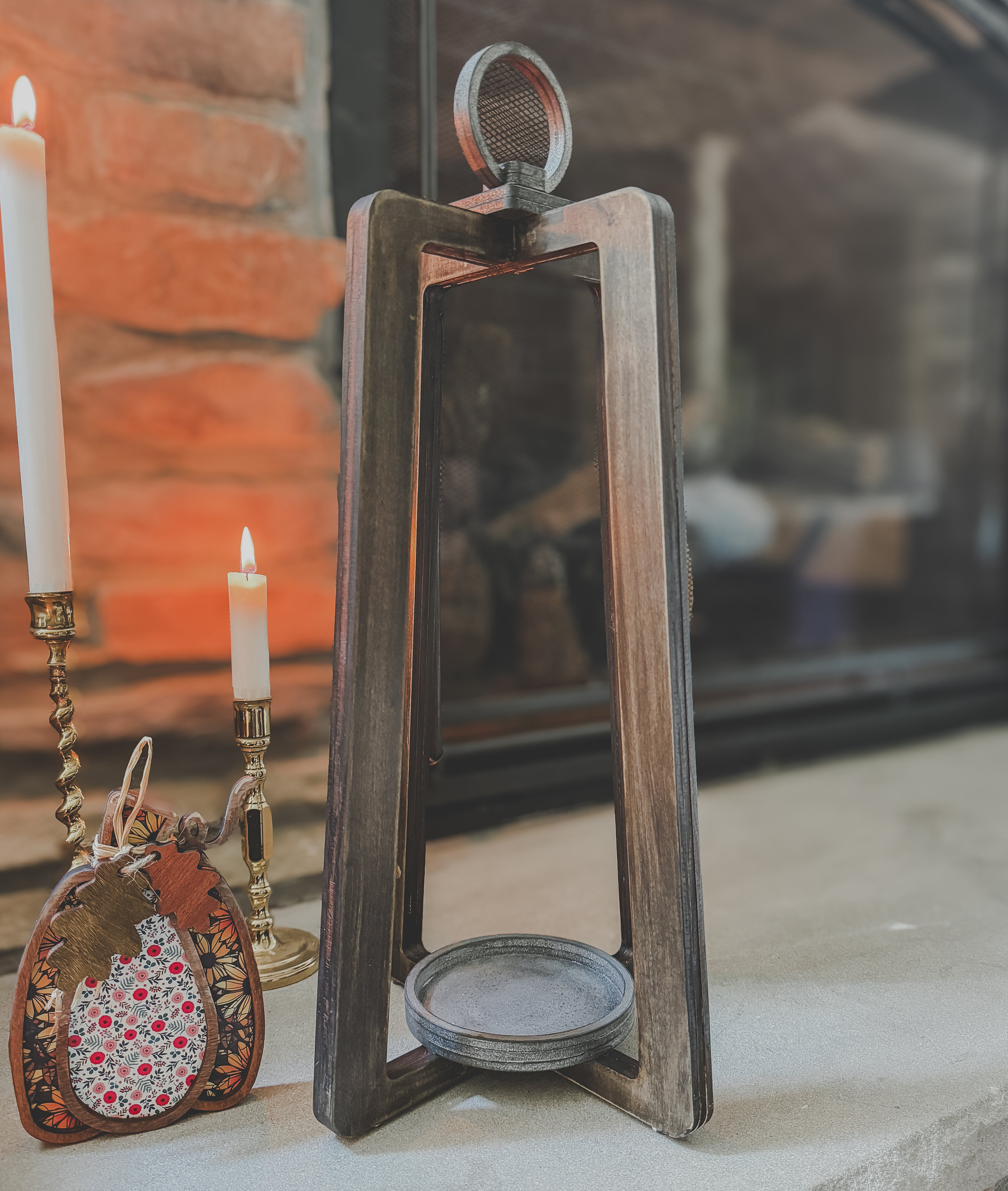Wood lantern with pumpkin in front of fireplace