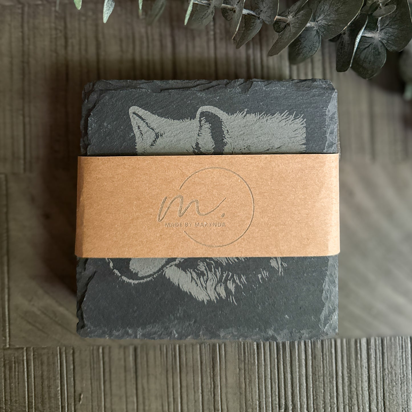 Stack of engraved wildlife profile slate coasters wrapped in kraft band with Made by Marynda logo – rustic gift packaging