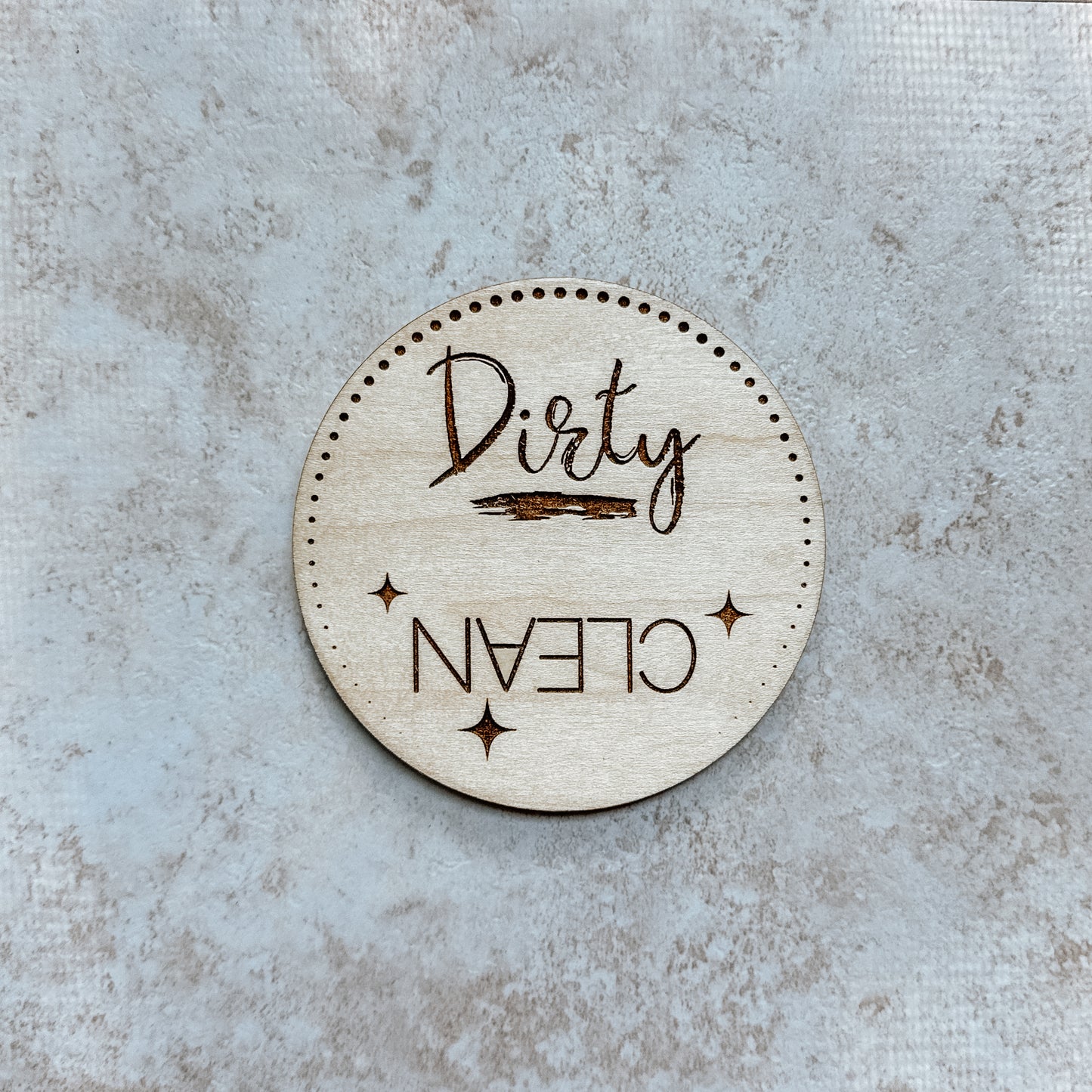 Round wooden sign with 'Dirty' and 'Clean' text on a textured surface