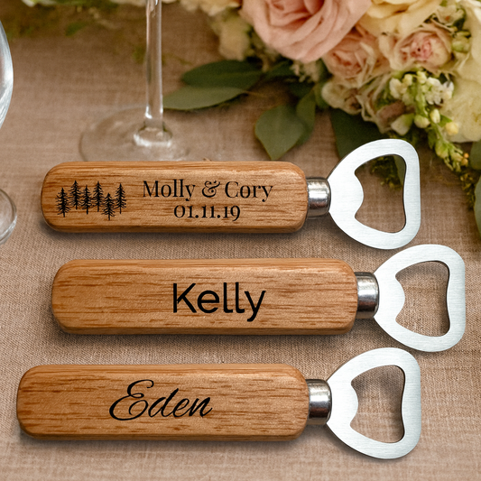 Three wooden bottle openers with engraved names on a table with flowers and glasses.
