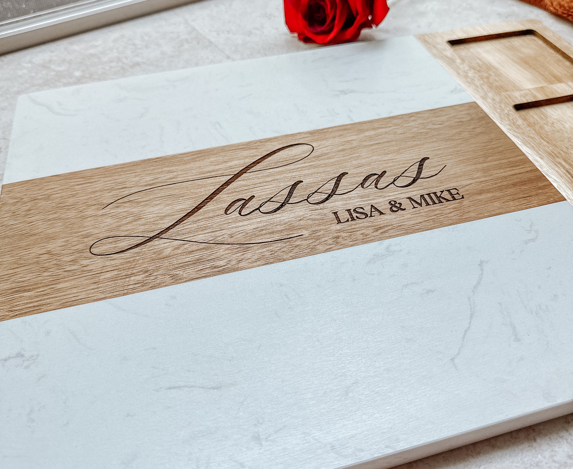 Wooden plaque with 'Lassas' and 'Lisa & Mike' engraved on a white surface.
