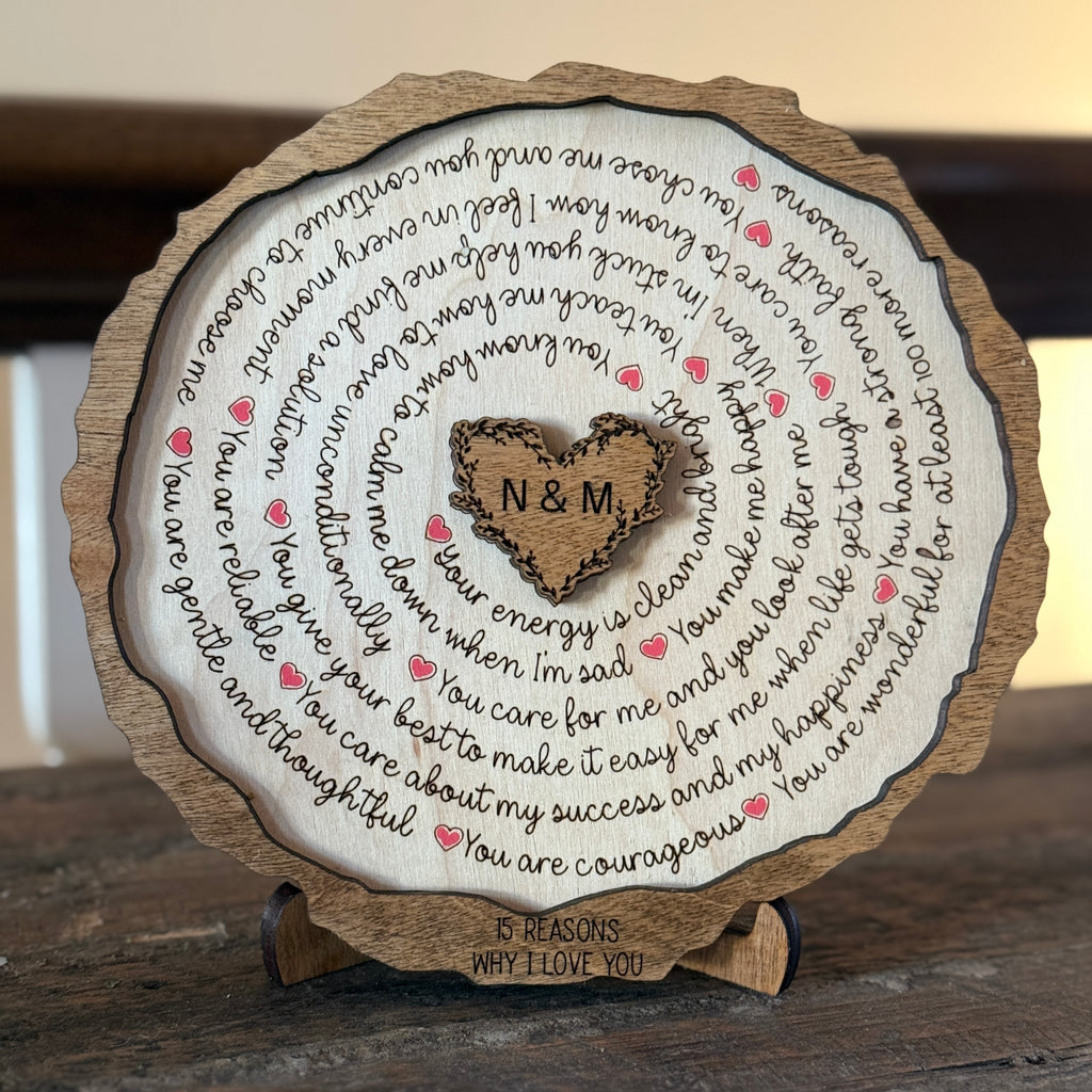 Close-up of engraved 15 Reasons I Love You wooden plaque with heart center initials and red hearts on a stand.