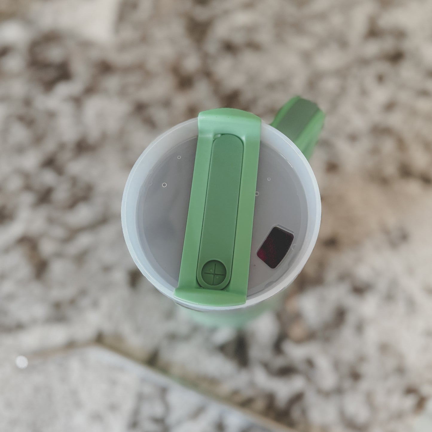 Top view of mint green 40oz tumbler with sip lid partially open, sitting on a marble countertop

