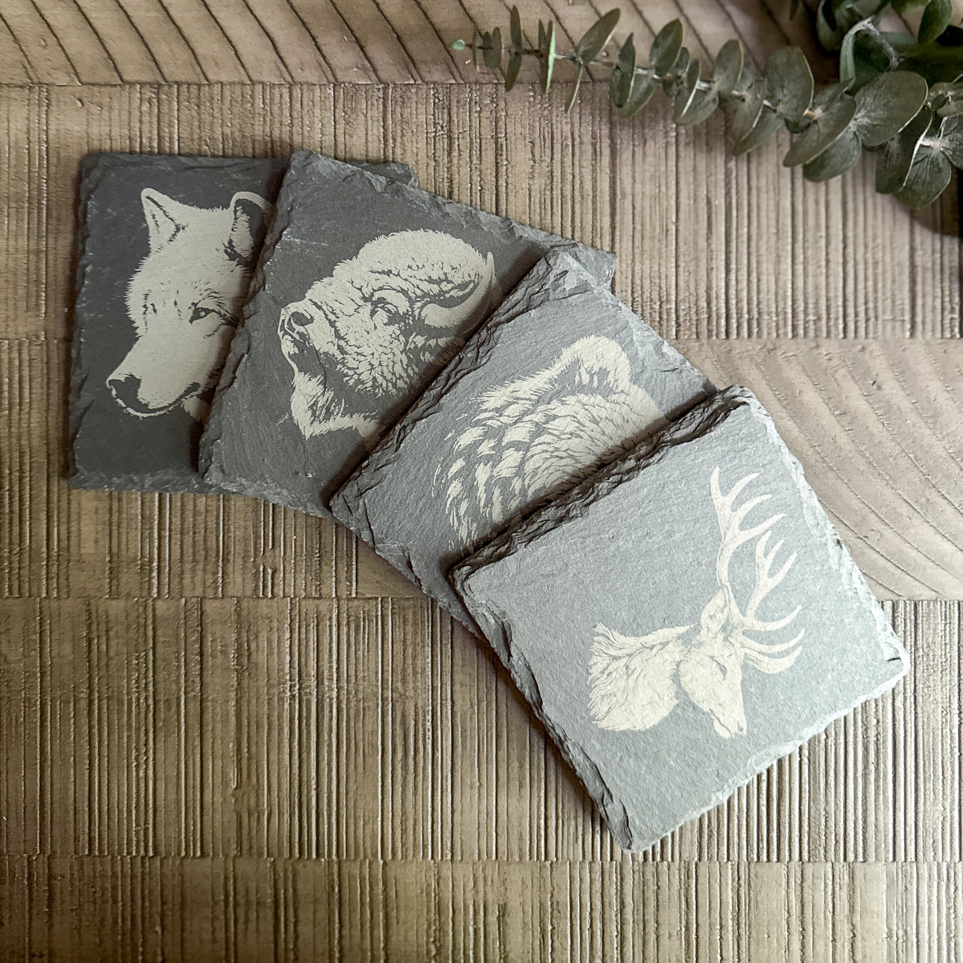 Set of 4 engraved slate coasters featuring detailed animal profiles – wolf, bison, owl, and elk – rustic wildlife decor