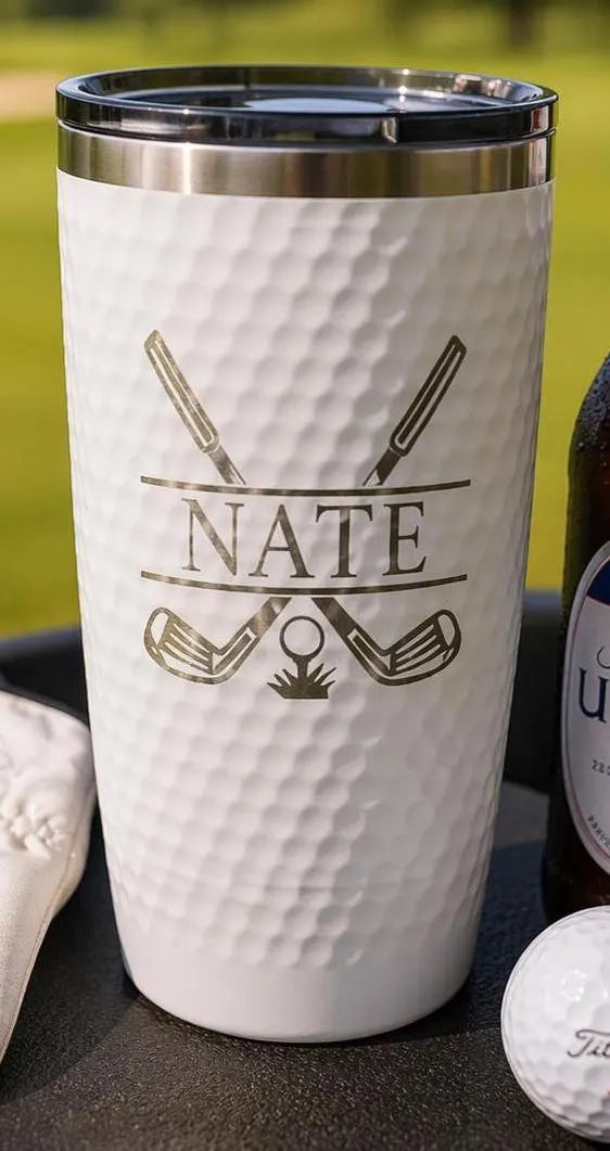 White tumbler with 'Nate' and golf-themed designs on a grassy background