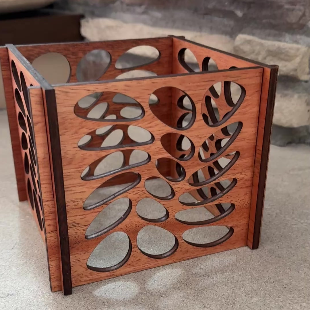 Video showing a wooden candle lantern with leaf cut-outs being rotated to display details and craftsmanship